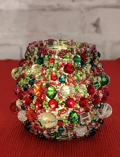 Värikkäillä ja erikokoisilla helmillä koristeltu lasipurkki